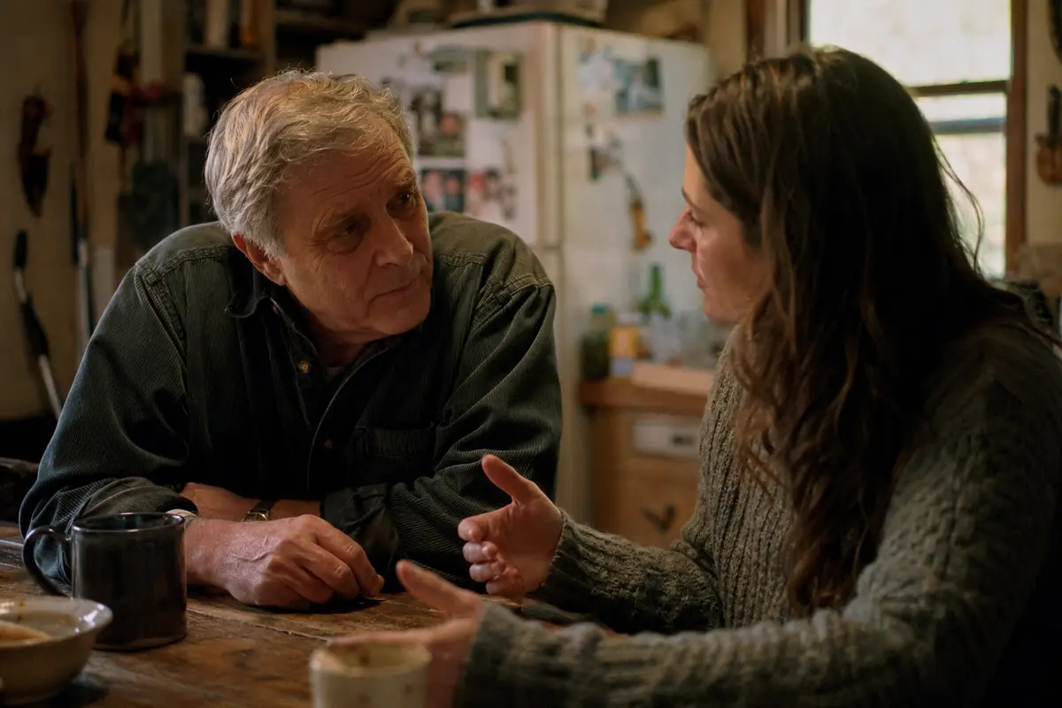 Two people sitting together at a kitchen table in quiet conversation