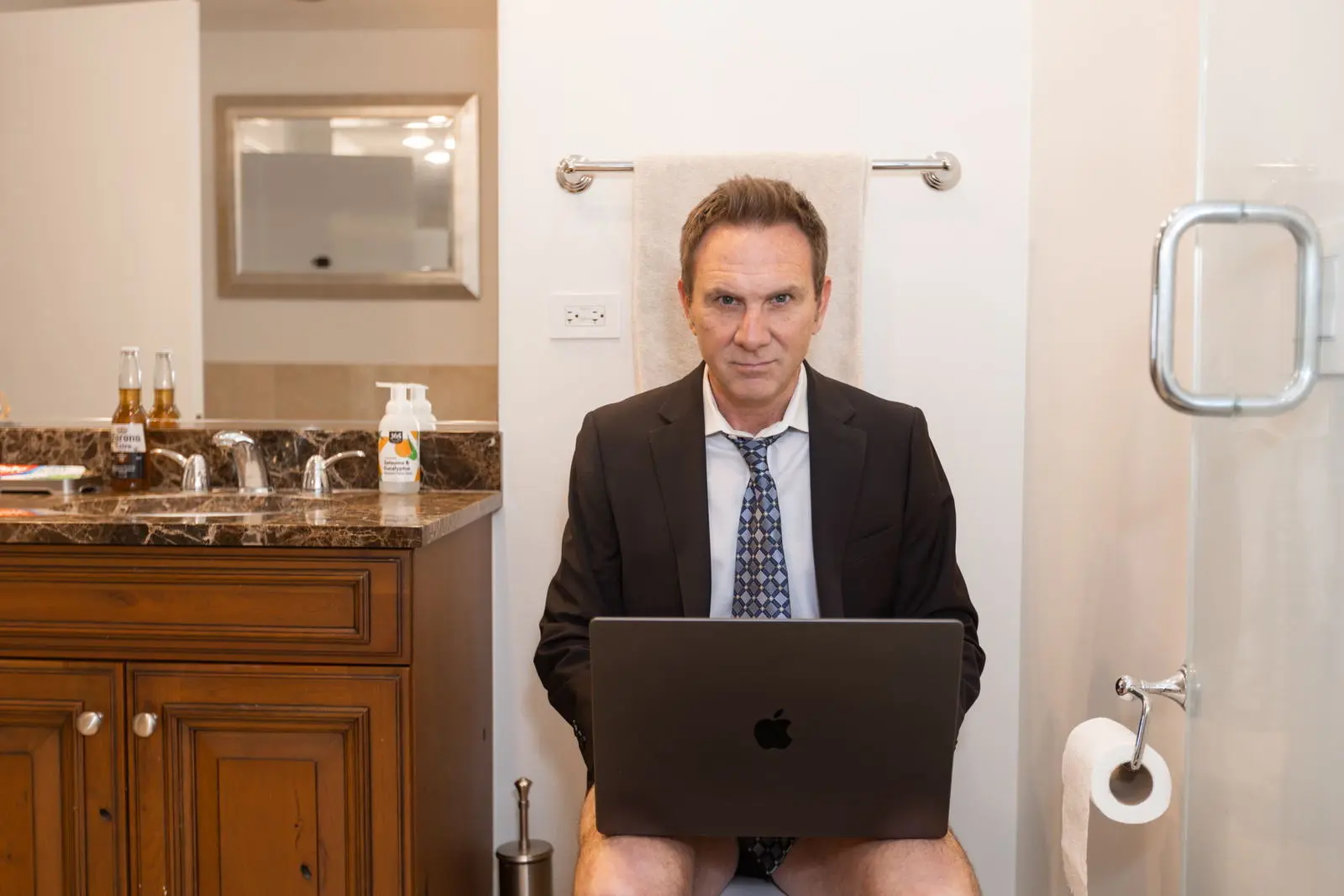 Totally Joking: a man in a suit reporting from the bathroom